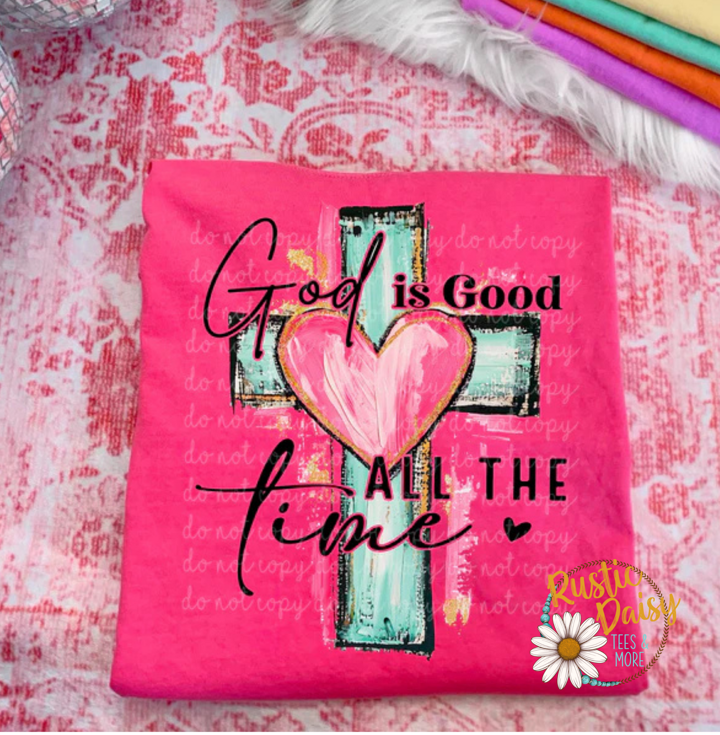T-shirt with God is Good All the Time text in black script with a pink heart on a turquoise cross