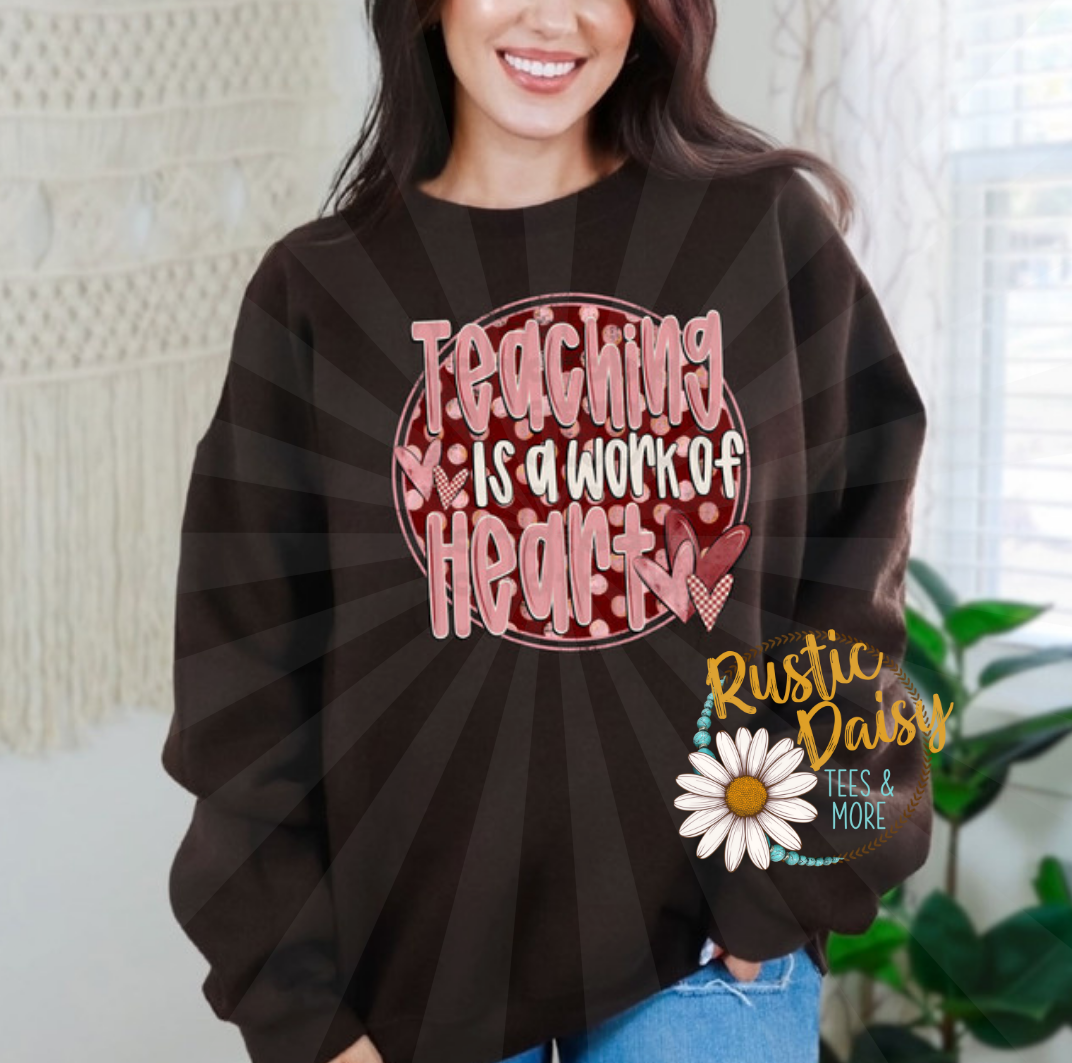 T-shirt with TEACHING IS A WORK OF HEART text in pink letters on red circle with hearts and polka dots