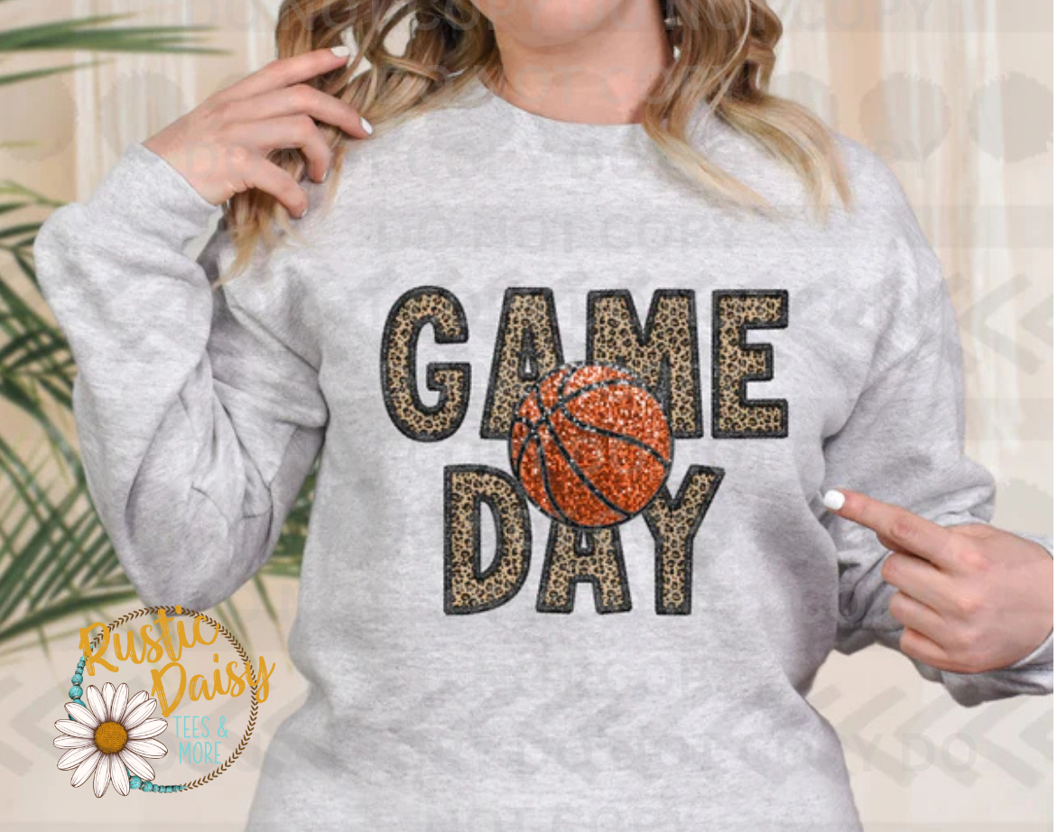 T-shirt with GAME DAY text in bold block letters filled with leopard print pattern and basketball with orange faux glitter