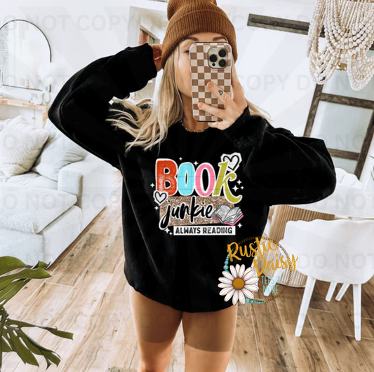 Book junkie always reading text with colorful letters, open book, hearts, and stars
