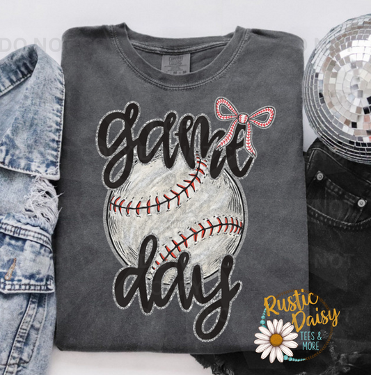 "Game Day" in black script over a distressed baseball with a faux glitter bow.