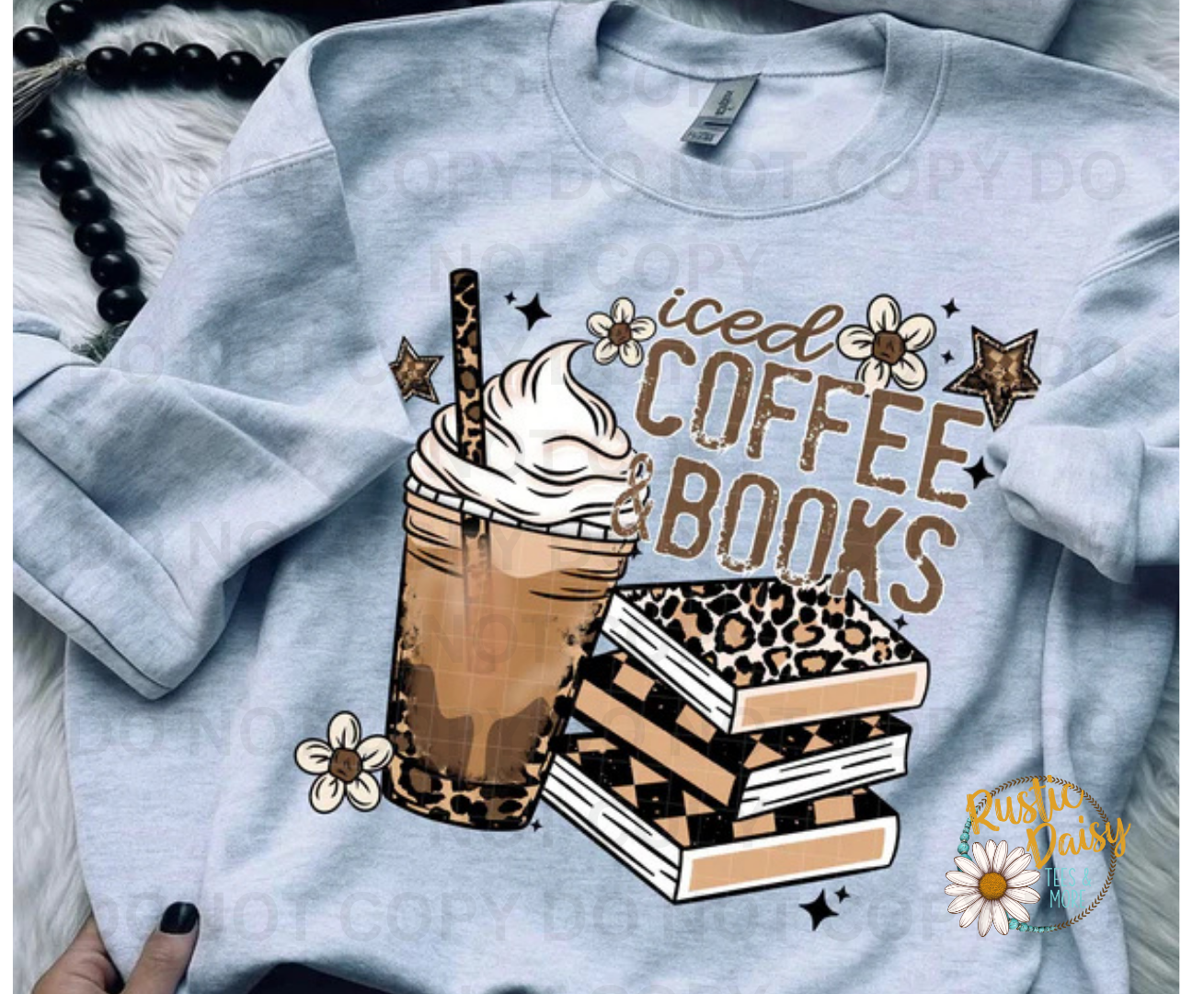 T-shirt with iced COFFEE BOOKS in brown text, iced coffee image with whipped cream in leopard print cup and stack of books with leopard print pattern and stars