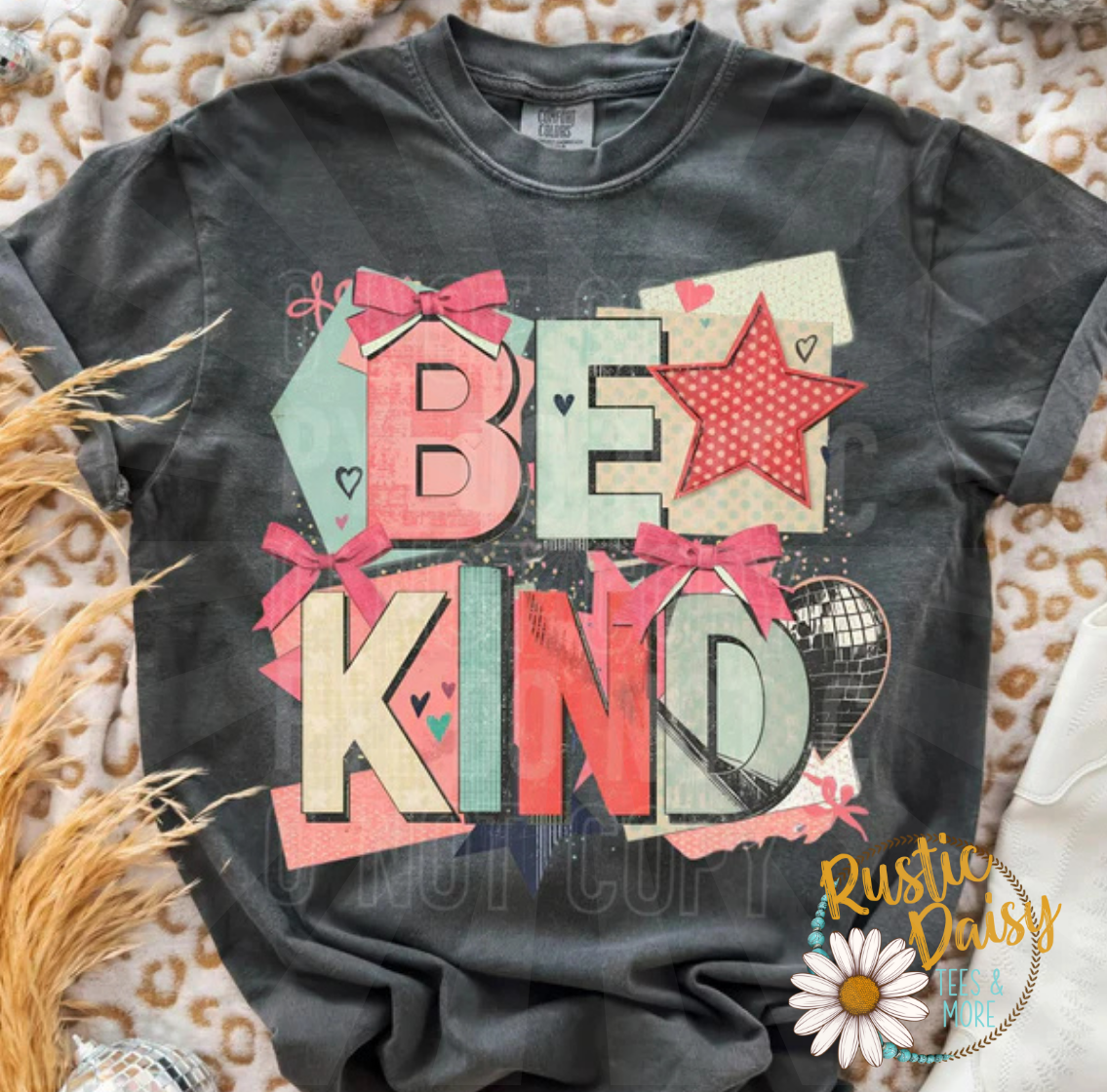 T-shirt with Be Kind text in colorful patterned letters accented with bows, star, and a colorful background graphic