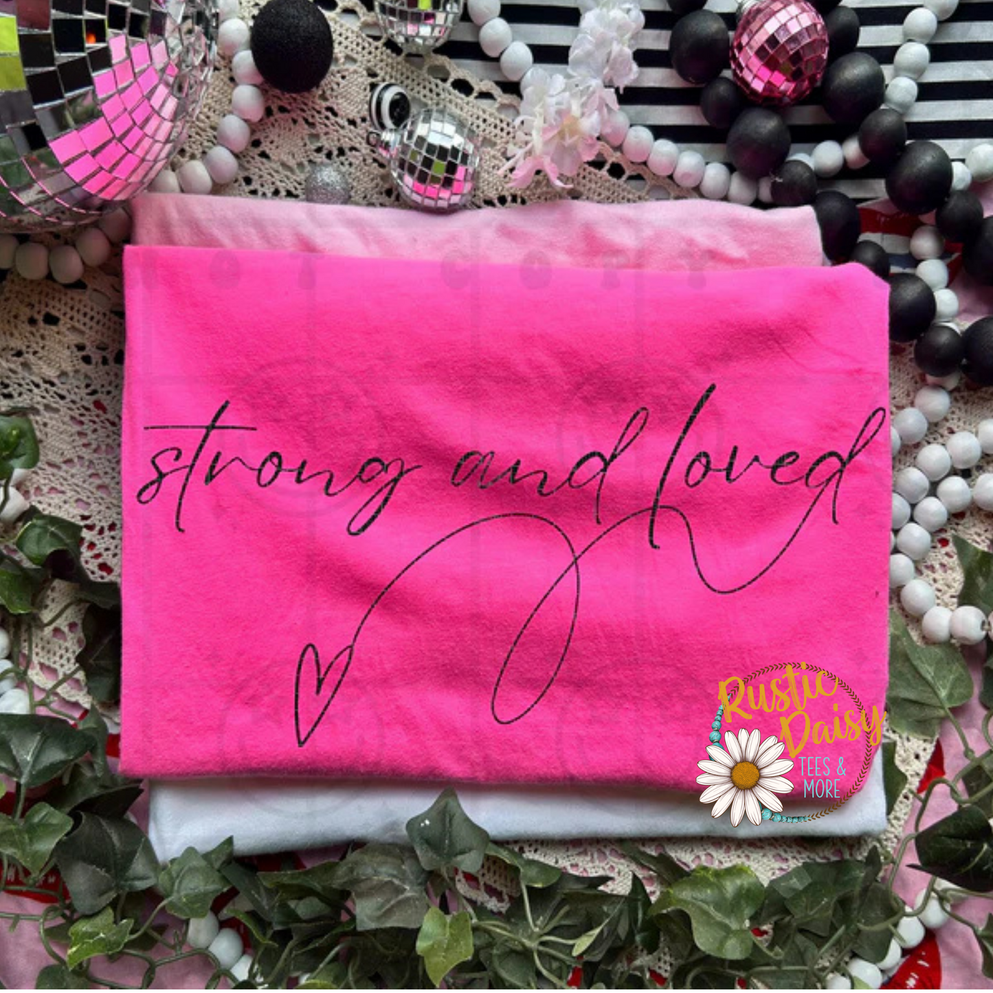T-shirt with strong and loved text in script lettering with heart in black