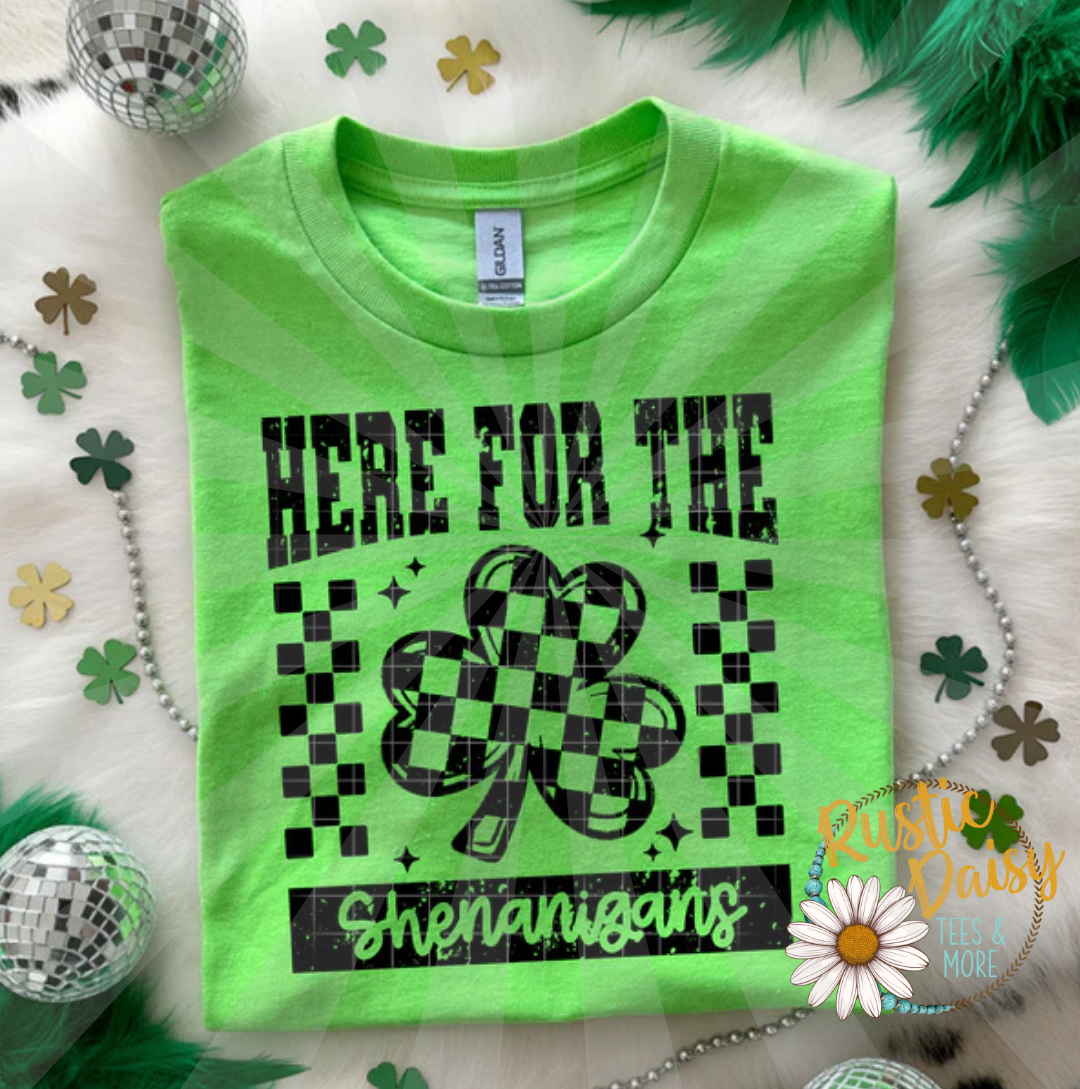 T-shirt with HERE FOR THE Shenanigans text, checkered shamrock, and checkered accents all in black.