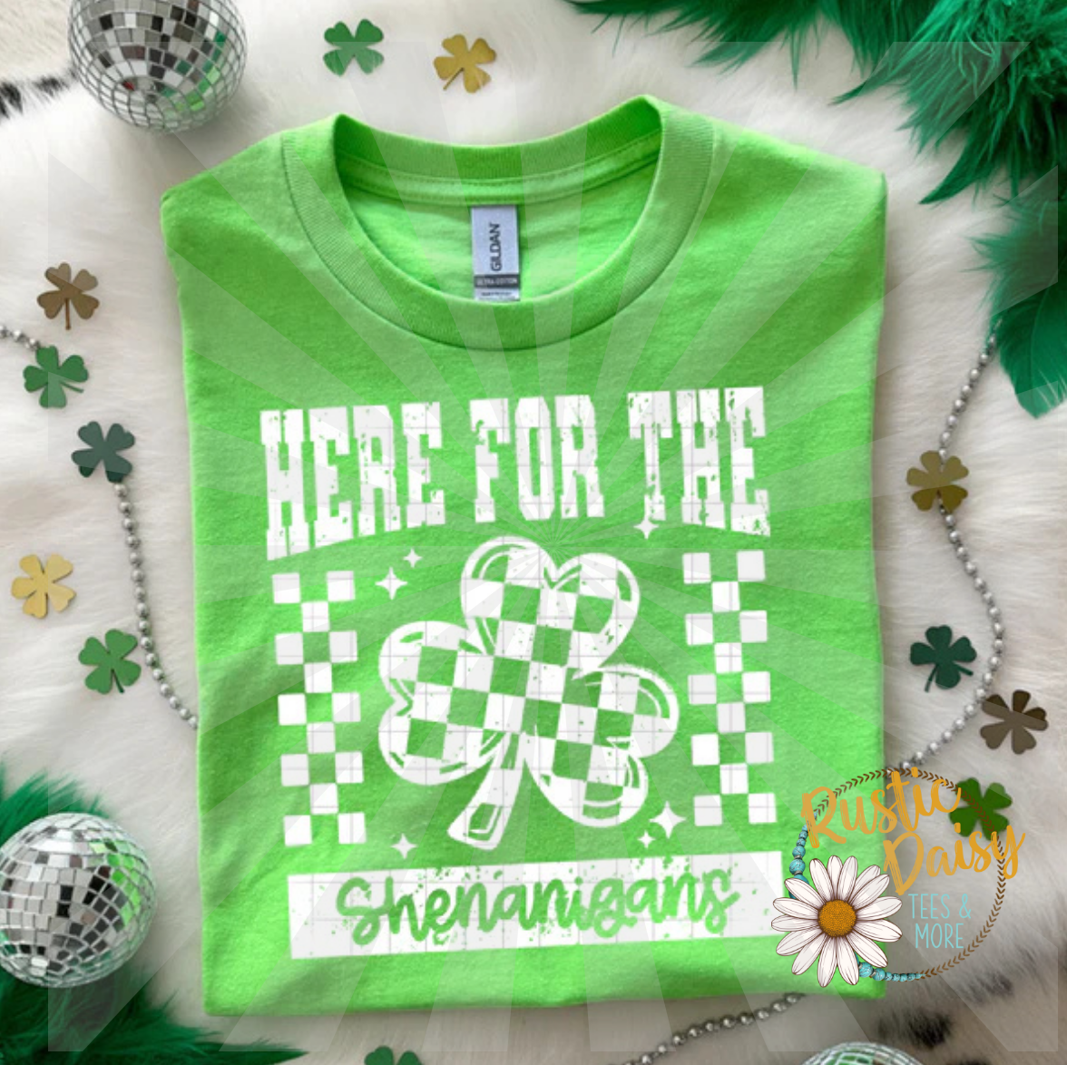 T-shirt with HERE FOR THE Shenanigans text, checkered shamrock, and checkered accents all in white.