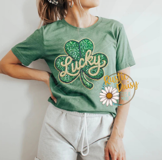 T-shirt with Lucky text in script lettering on green faux glitter shamrock