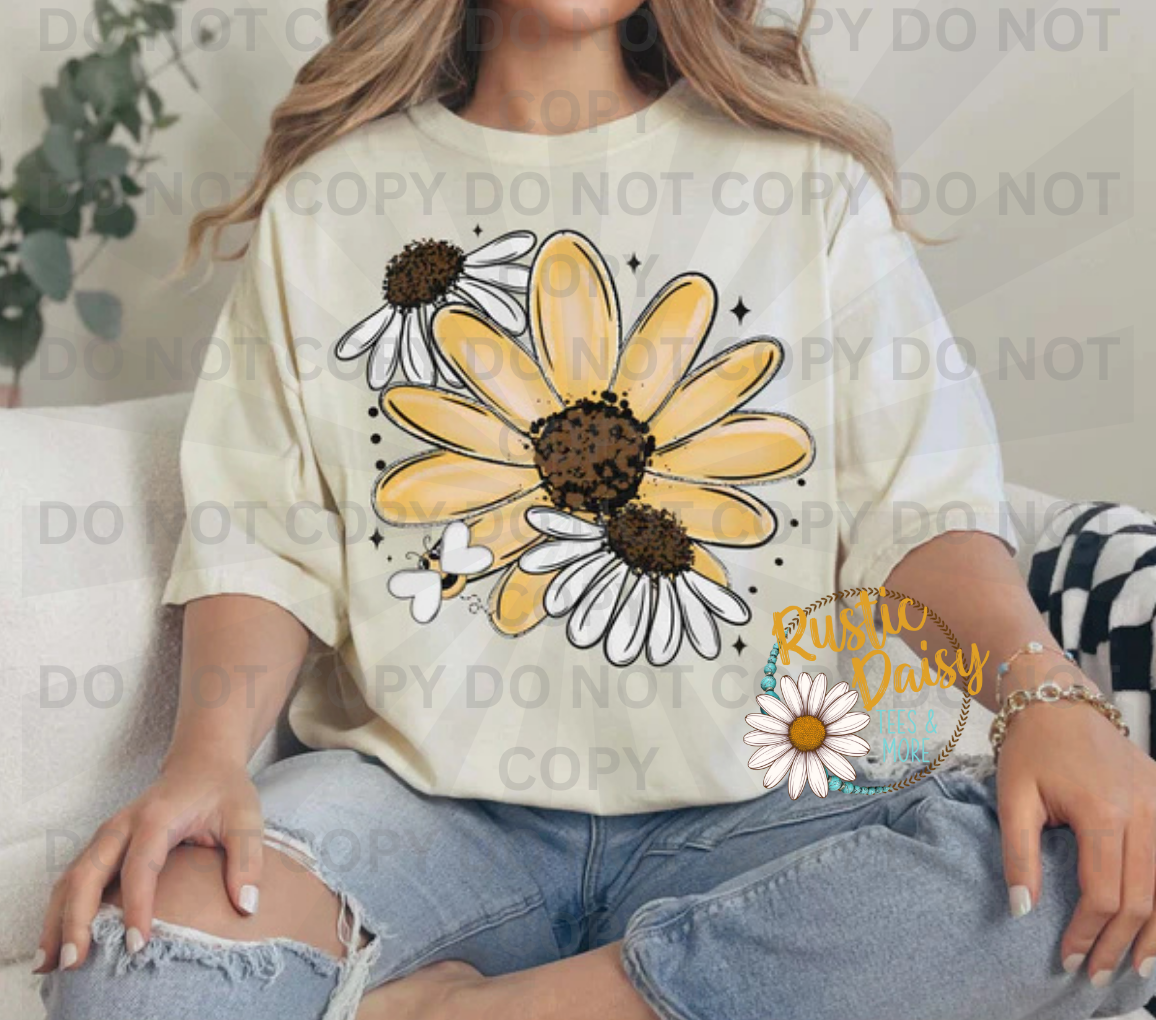 Three yellow and white daisies with brown and black speckled centers and bee