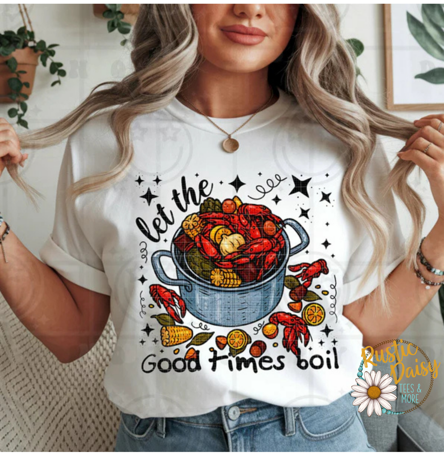 T-shirt with let the Good times boil text with crawfish boil pot filled with corn, potatoes, crawfish, and lemon slices with stars