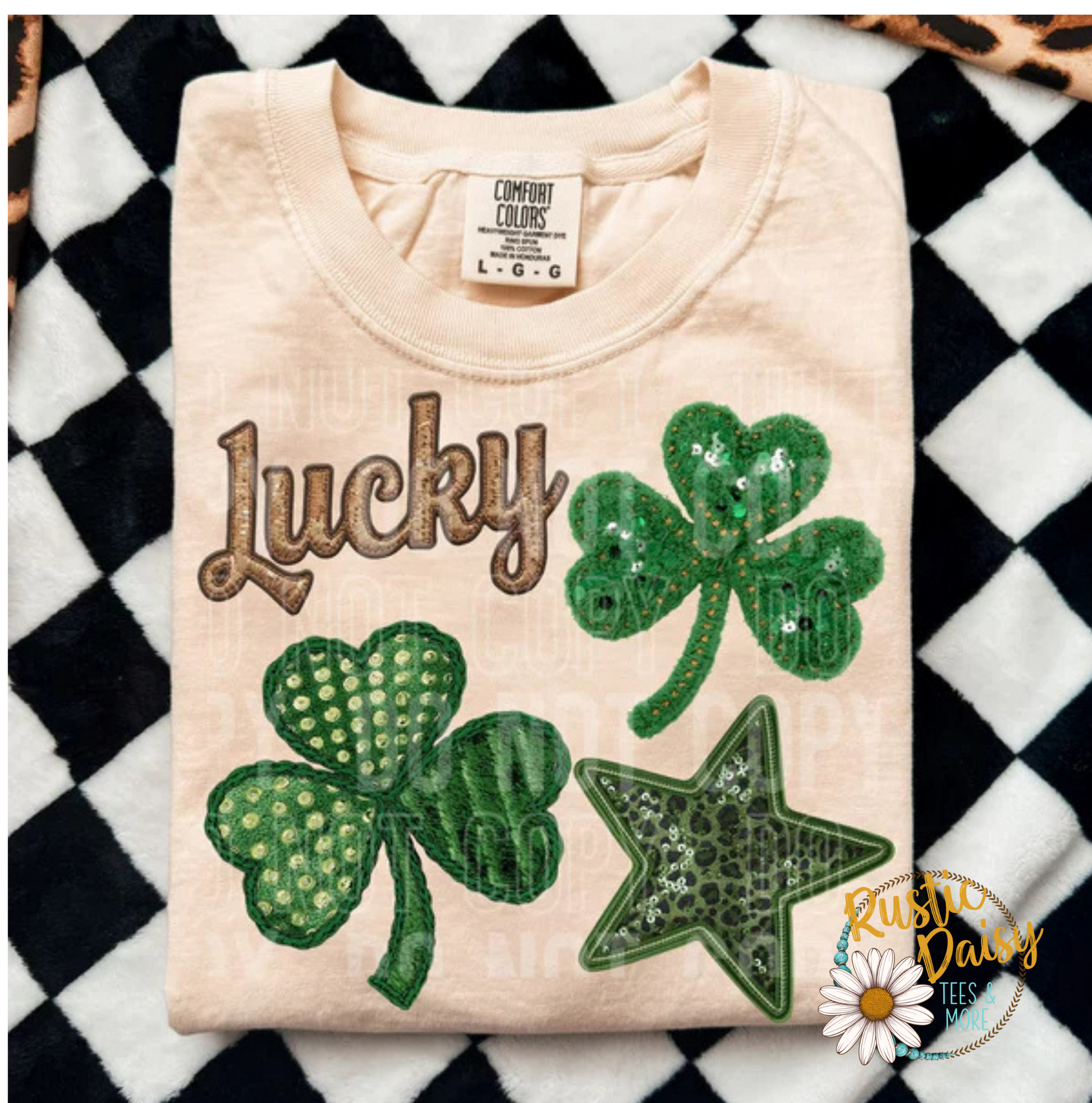 T-shirt with Faux sequin Lucky text in script lettering with multiple faux sequin 
shamrocks in different patterns and green star