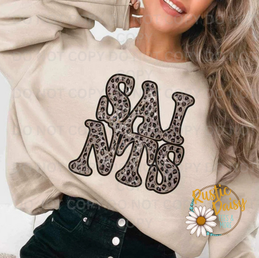 T-shirt with SAINTS text in retro wavy letters filled with leopard print pattern